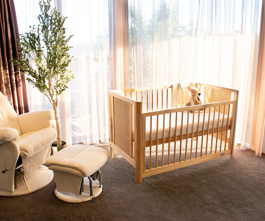 Natural Babyhood Aliya Rattan Cot in a sunlit nursery