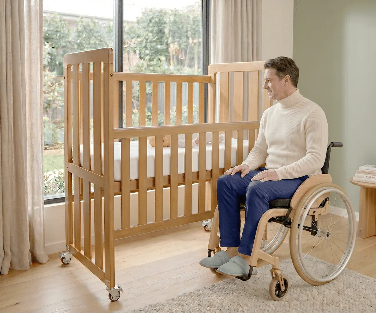 Carer reaching into the raised Babyhood Ergonomic Cot