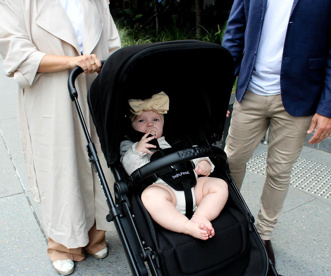 Child secured in the Doppio Plus seat with its five-point harness and bumper bar
