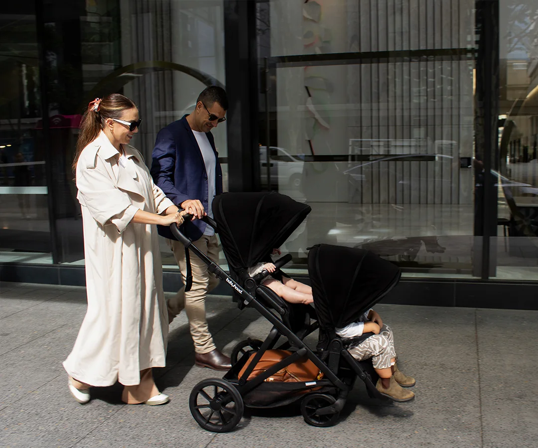 Family pushing the Babyhood Doppio Plus configured with two inline seats