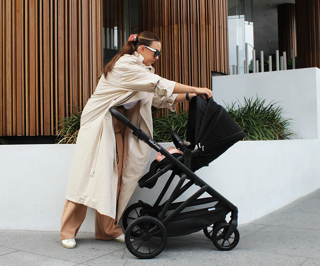 Parent adjusting the Doppio Plus seat in its lay-flat newborn position